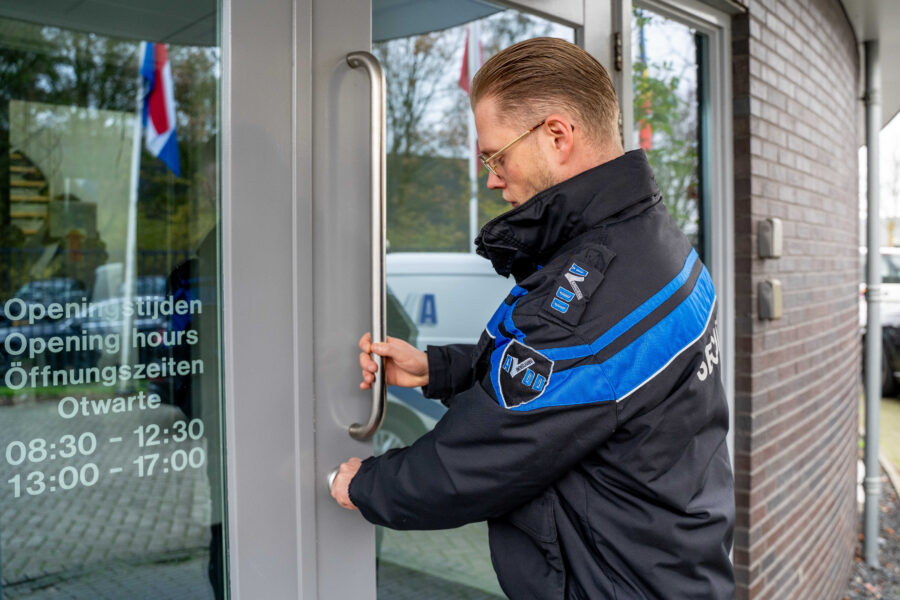 Mannelijke beveiliger van AVDD draait de deur op slot