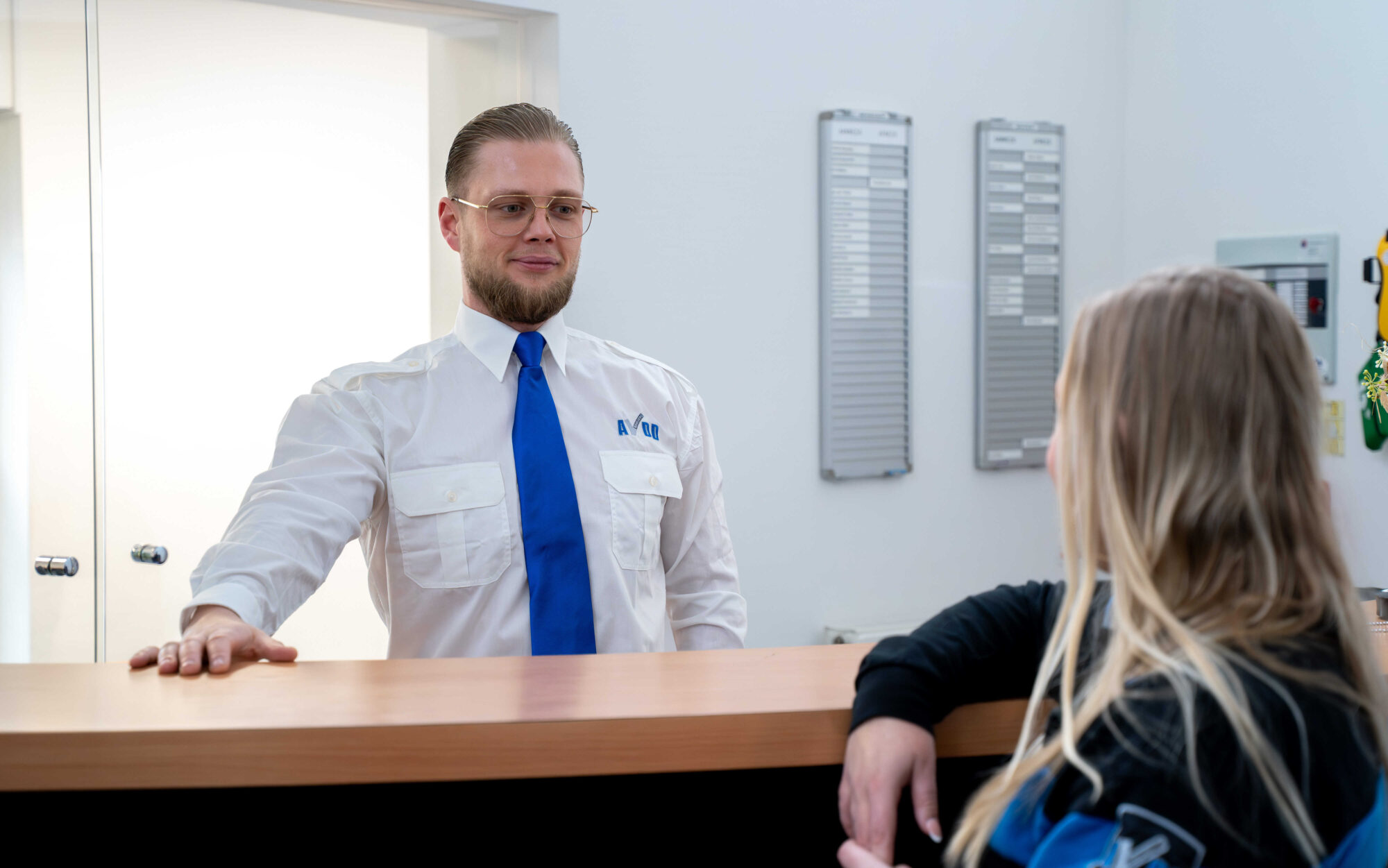 Medewerker van AVDD achter de receptie pratend met een collega beveiligingsbedrijf - receptiediensten